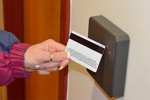 Person holding master key card up to a card reader.