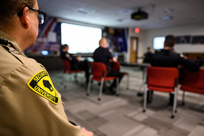 UW Police Department law-enforcement and security officers gather in a conference room for a debriefing.