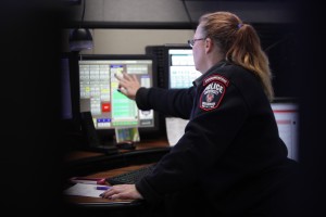 A dispatcher works in front of a bank of monitors.