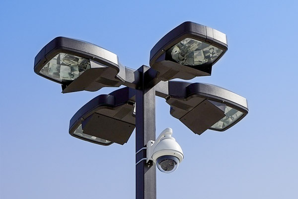 A light pole with lights and security camera.