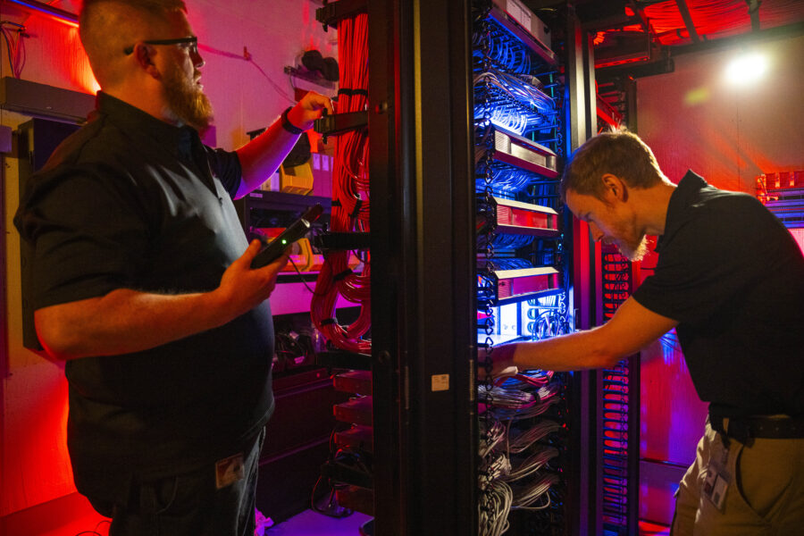 two IT workers, working in the network room at UWPD